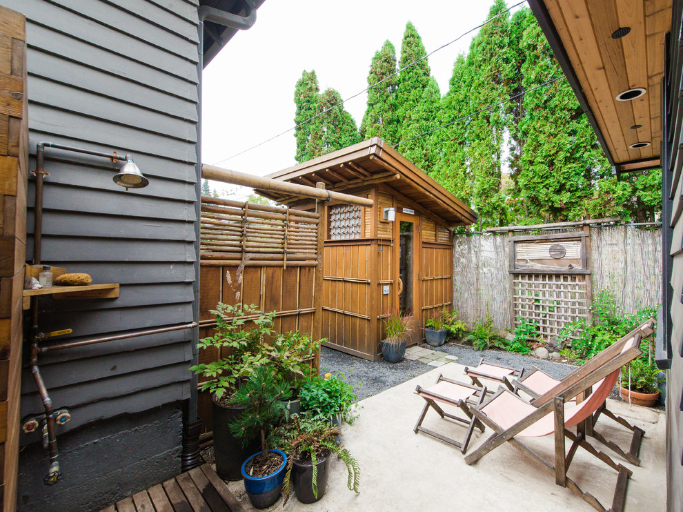 Diseño de patio de estilo zen sin cubierta en patio trasero con losas de hormigón