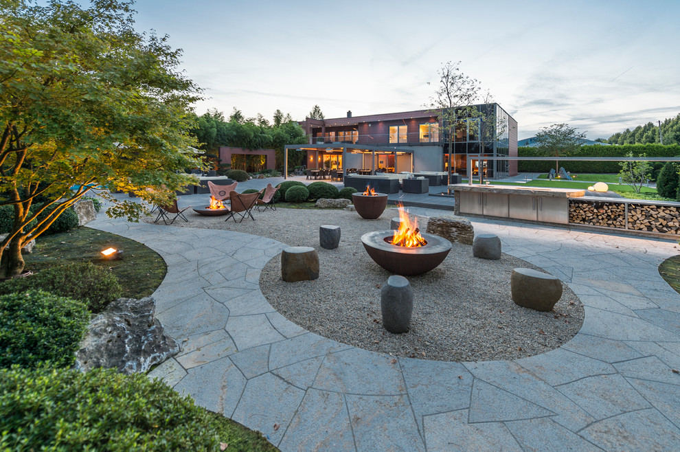 Inspiration for an expansive contemporary patio in Leipzig with natural stone paving and a bbq area.