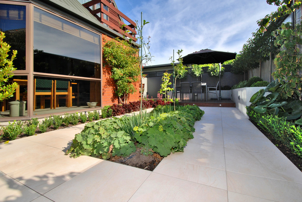 Diseño de patio contemporáneo de tamaño medio sin cubierta en patio trasero con adoquines de piedra natural