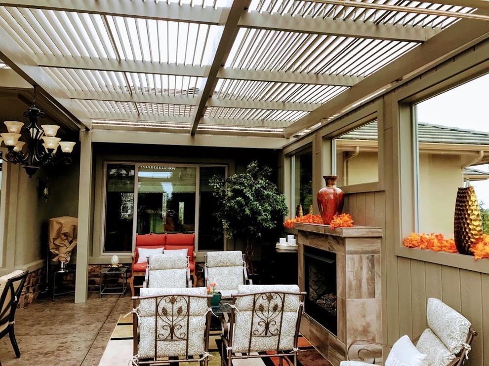 На фото: большой двор на заднем дворе в средиземноморском стиле с летней кухней, покрытием из бетонных плит и козырьком