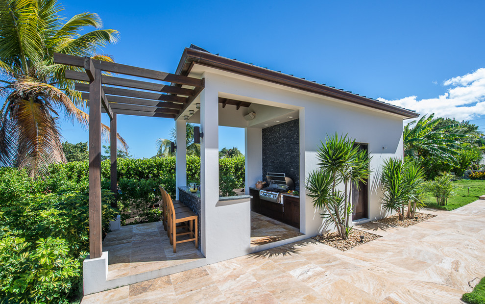 Example of an island style patio design in Other with a pergola