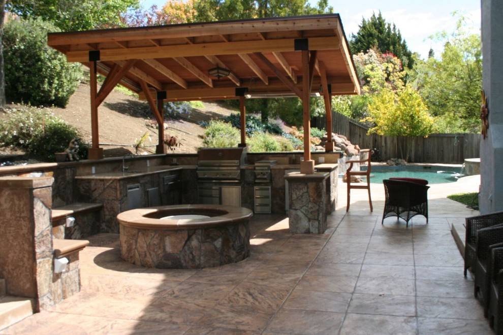 Foto de patio tradicional grande en patio trasero con cocina exterior, suelo de hormigón estampado y pérgola