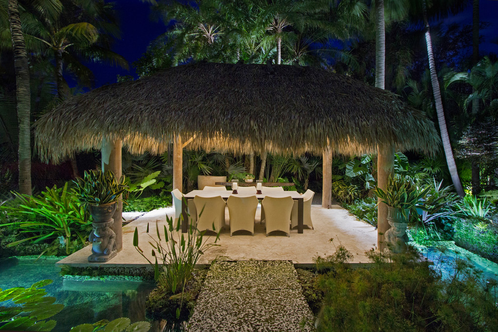 Exemple d'une terrasse arrière exotique avec un point d'eau et un gazebo ou pavillon.