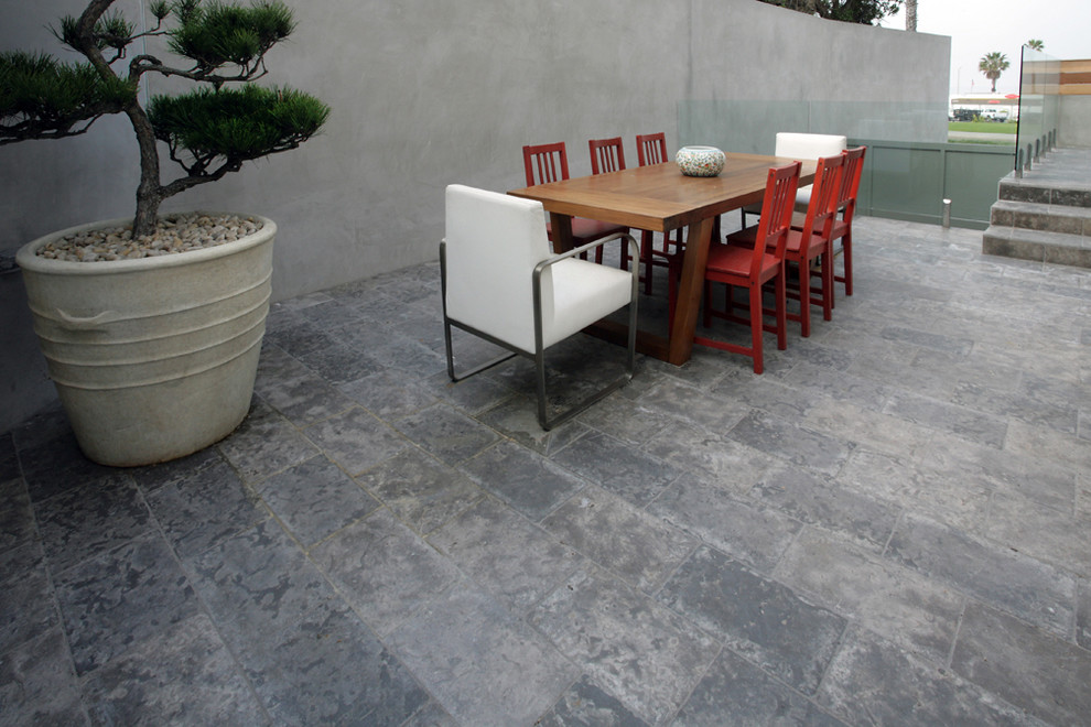 Photo of a large contemporary back patio in Los Angeles with natural stone paving and no cover.