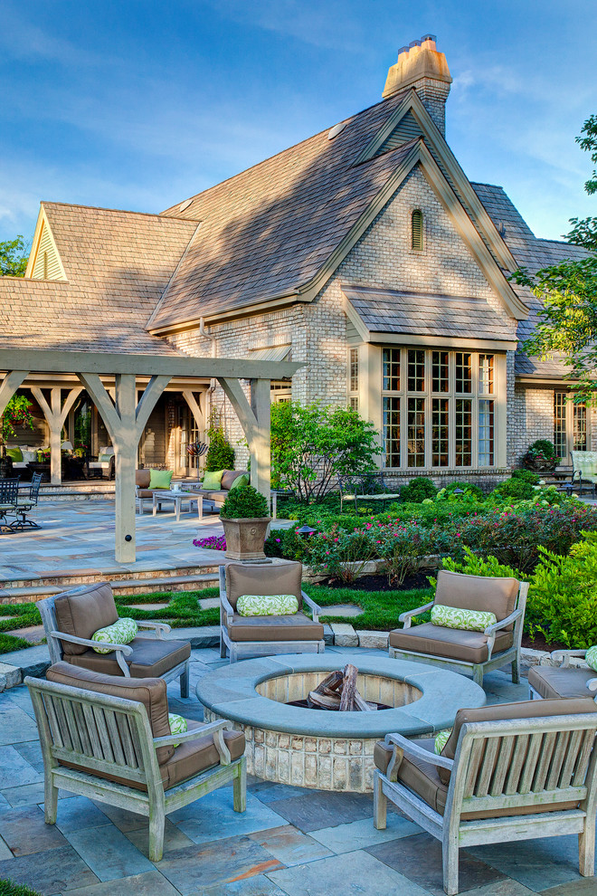 Große Klassische Pergola hinter dem Haus mit Feuerstelle und Natursteinplatten in Chicago