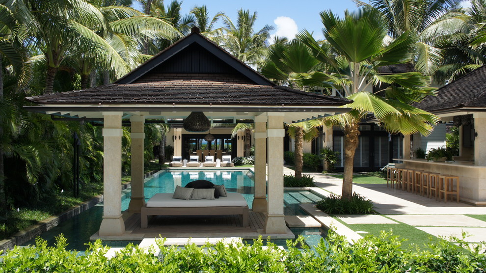 Immagine di un ampio patio o portico tropicale dietro casa con piastrelle e un gazebo o capanno