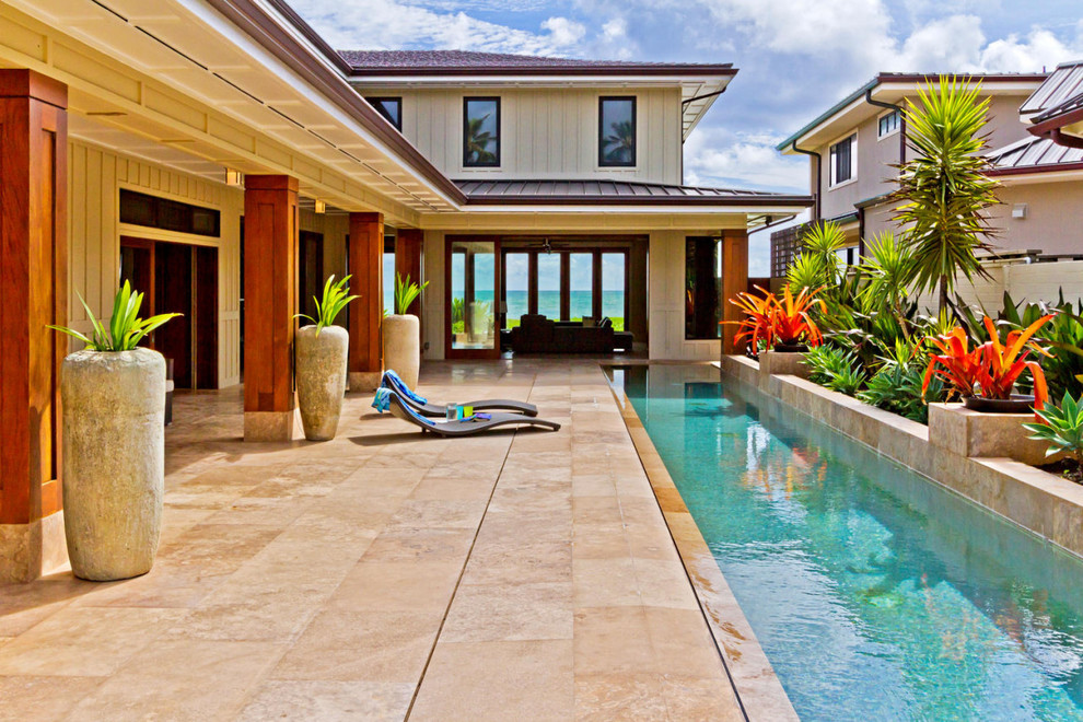 Large island style backyard tile patio photo in Hawaii with a roof extension