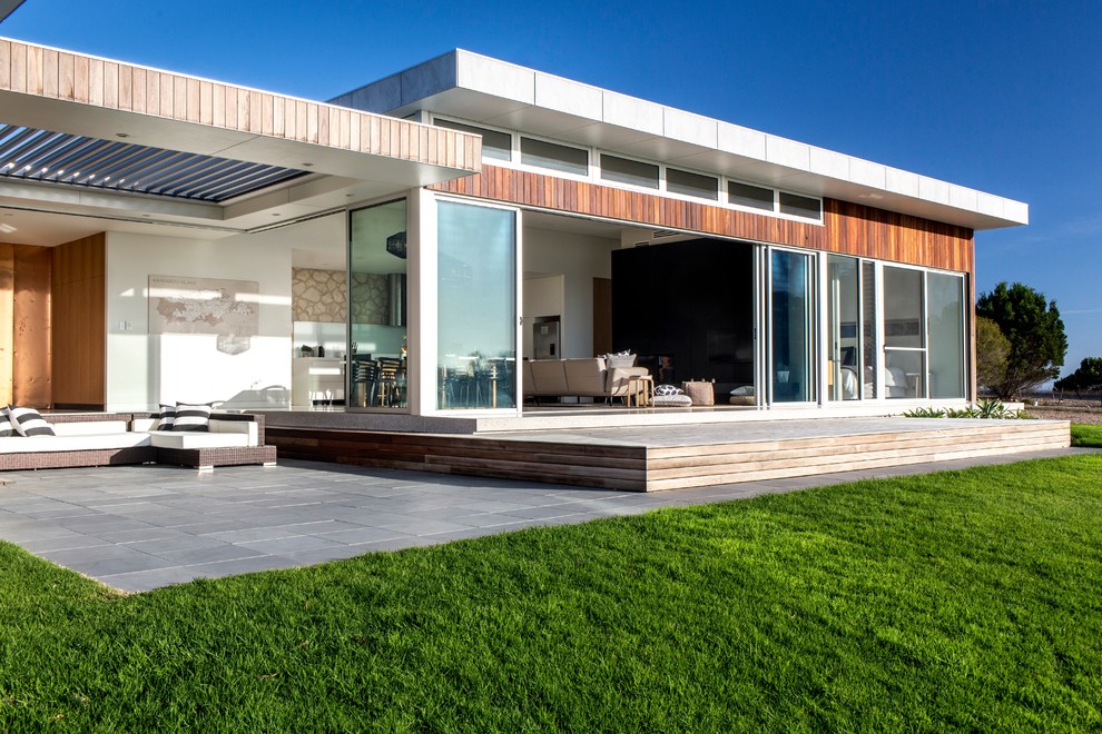 Idées déco pour une grande terrasse arrière moderne avec une cuisine d'été, des pavés en béton et un auvent.