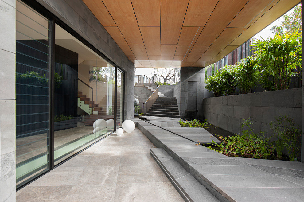 Пример оригинального дизайна: двор в современном стиле с фонтаном, покрытием из плитки и навесом
