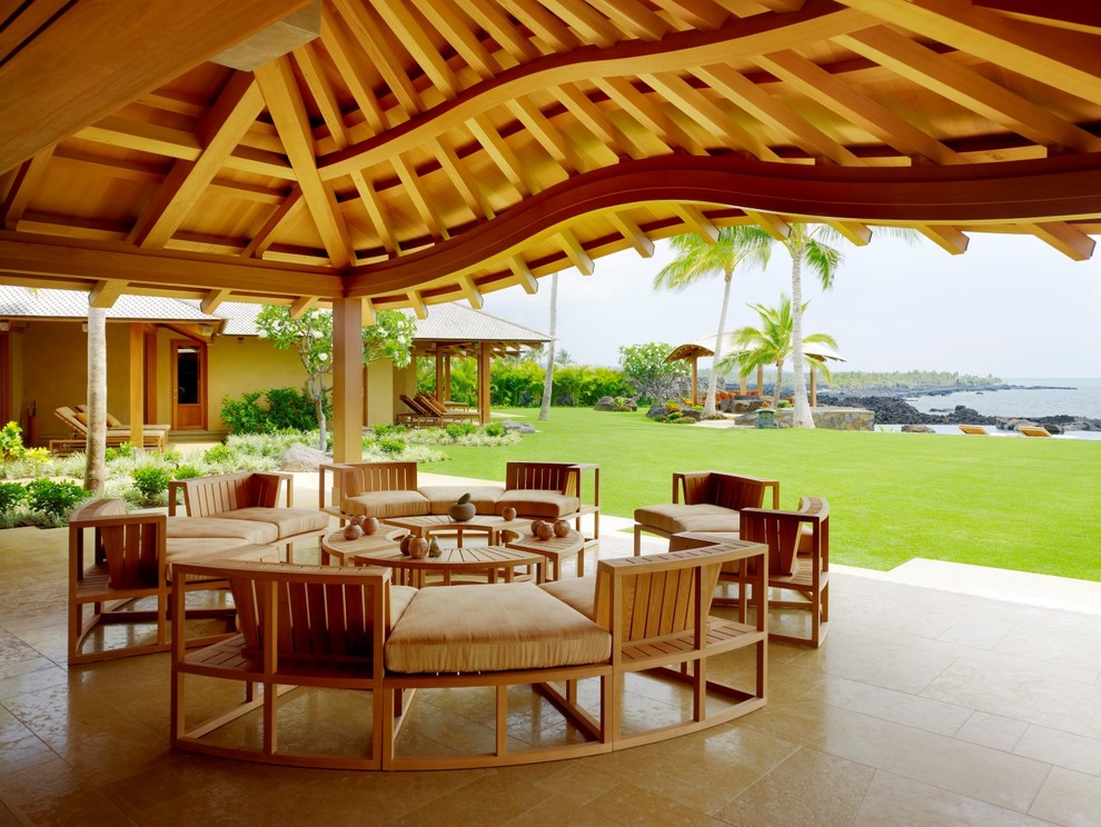Idee per un patio o portico tropicale dietro casa con un tetto a sbalzo