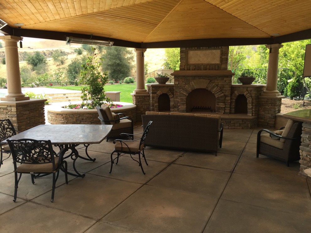 Large mediterranean back patio in Los Angeles with an outdoor kitchen, concrete slabs and a pergola.