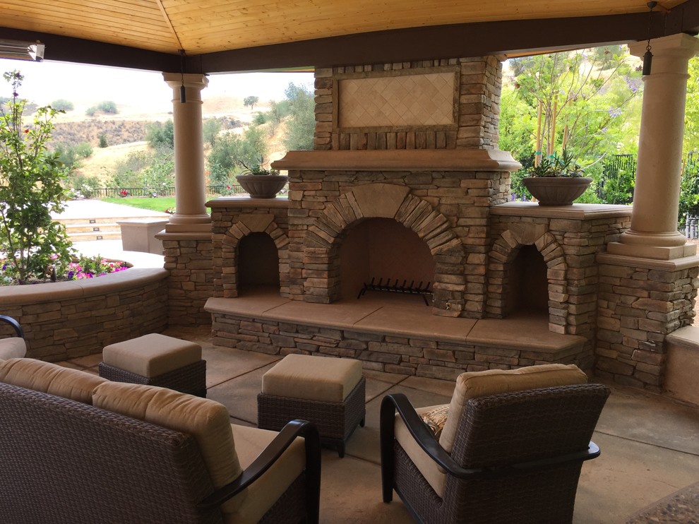 Large mediterranean back patio in Los Angeles with an outdoor kitchen, natural stone paving and a pergola.