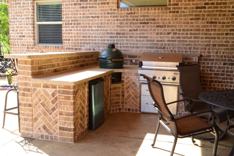 Réalisation d'une terrasse arrière chalet de taille moyenne avec une cuisine d'été et du béton estampé.