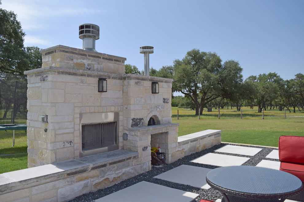 Inspiration for a mid-sized country side yard concrete paver patio remodel in Austin with a fireplace and no cover