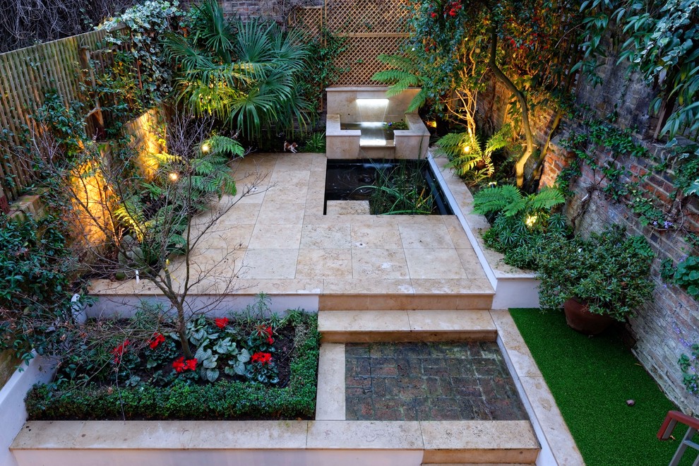 Idée de décoration pour une petite terrasse arrière tradition avec un point d'eau et des pavés en pierre naturelle.