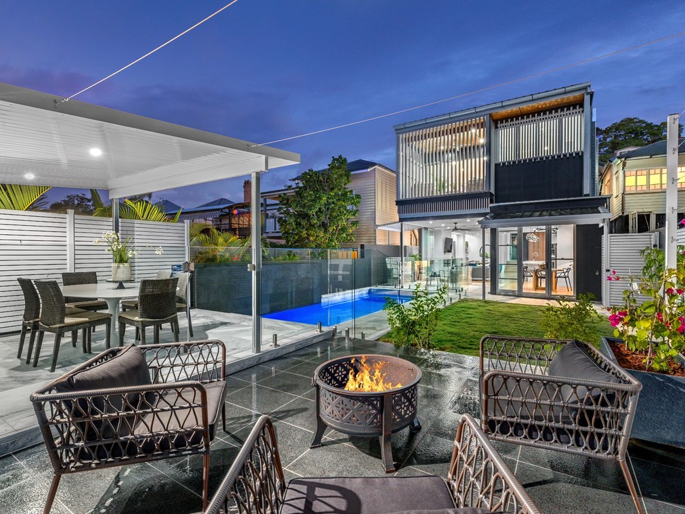 Design ideas for a contemporary back patio in Brisbane with fencing.