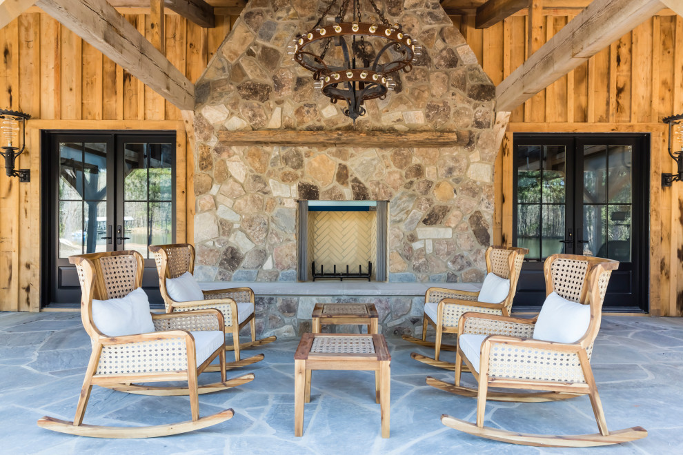 Rural patio in Raleigh with a fireplace, natural stone paving and a roof extension.