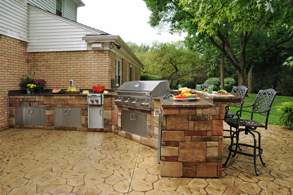 Large traditional back patio in Other with an outdoor kitchen, stamped concrete and no cover.