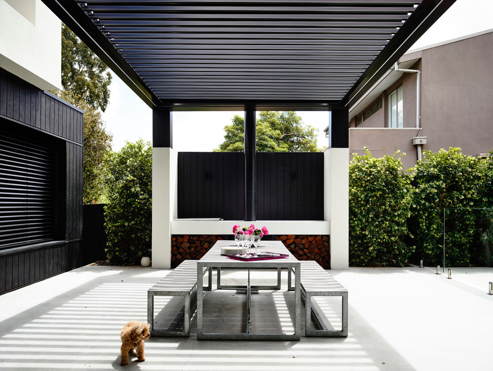 Imagen de patio moderno en patio trasero con cocina exterior, losas de hormigón y pérgola
