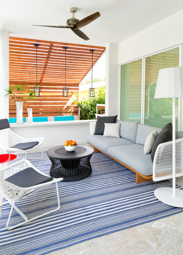 Inspiration for a medium sized beach style patio in Miami with tiled flooring and a roof extension.