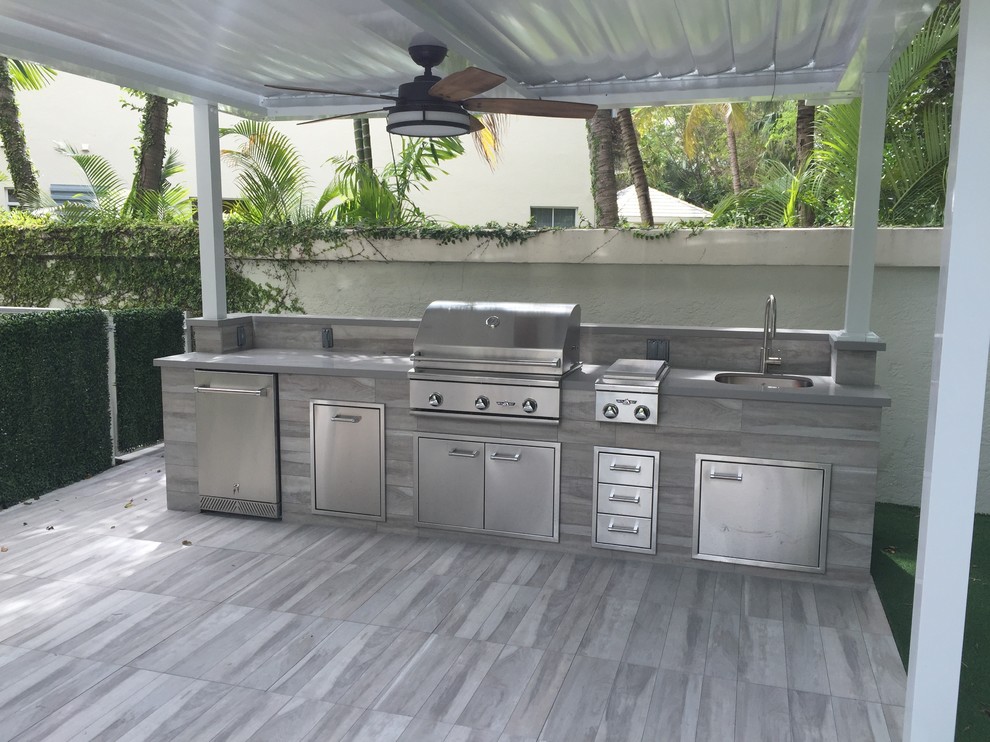 Medium sized contemporary back patio in Miami with an outdoor kitchen, tiled flooring and a pergola.