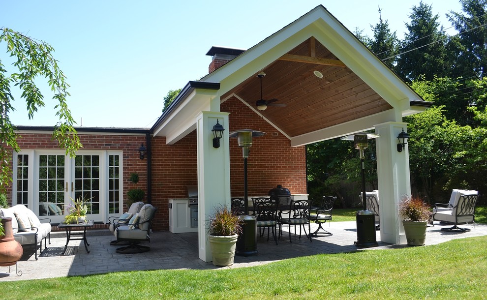 Idée de décoration pour une terrasse arrière tradition de taille moyenne avec une cuisine d'été, des pavés en béton et une extension de toiture.