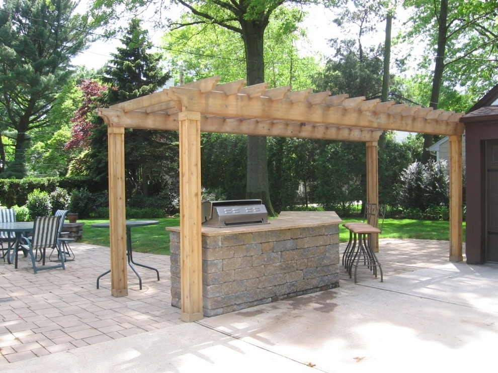 Diseño de patio tradicional en patio trasero con cocina exterior, adoquines de piedra natural y cenador