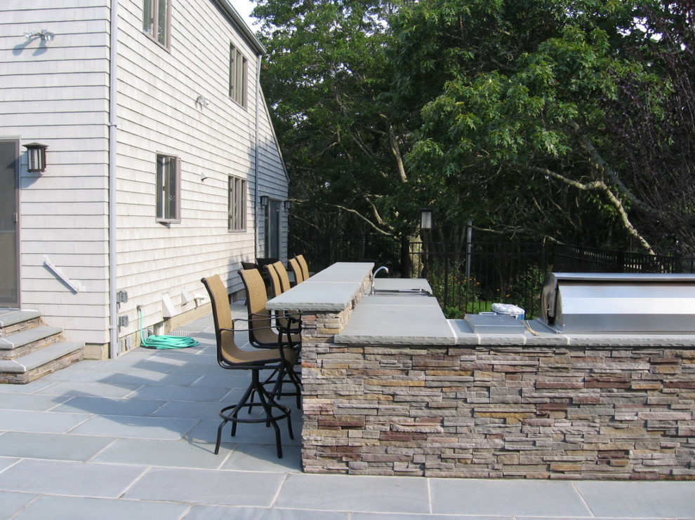 Klassischer Patio hinter dem Haus mit Outdoor-Küche, Natursteinplatten und Gazebo in New York