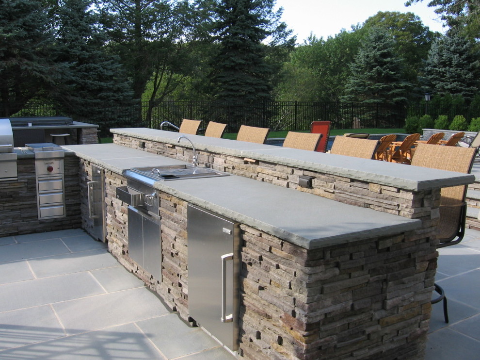 Traditional back patio in New York with an outdoor kitchen, natural stone paving and a gazebo.