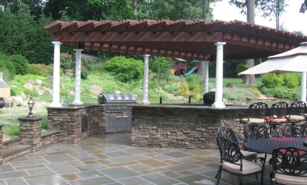 Inspiration for a timeless backyard stone patio kitchen remodel in New York with a gazebo