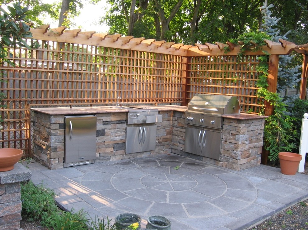 Foto de patio tradicional en patio trasero con cocina exterior, adoquines de piedra natural y cenador