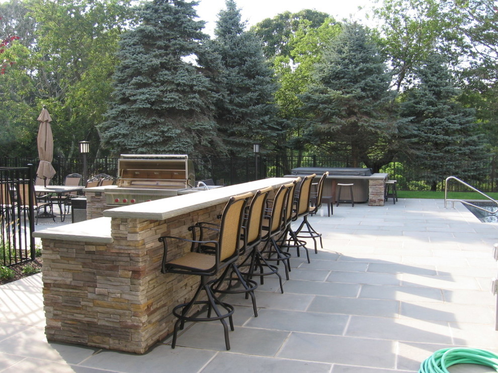 Klassischer Patio hinter dem Haus mit Outdoor-Küche, Natursteinplatten und Gazebo in New York