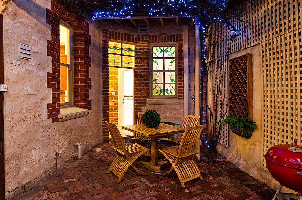 Ispirazione per un patio o portico tradizionale di medie dimensioni e dietro casa con pavimentazioni in mattoni