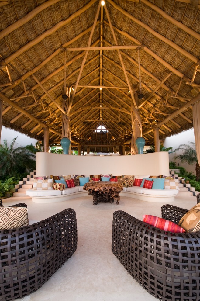 Ispirazione per un patio o portico tropicale con un tetto a sbalzo