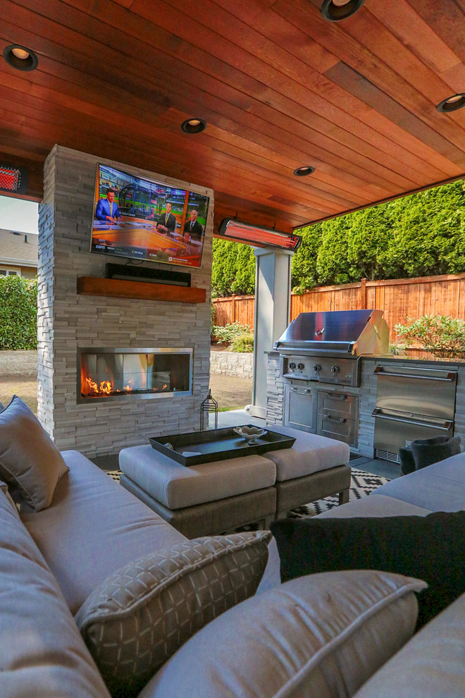 Inspiration for a mid-sized modern backyard concrete paver patio kitchen remodel in Seattle with a roof extension