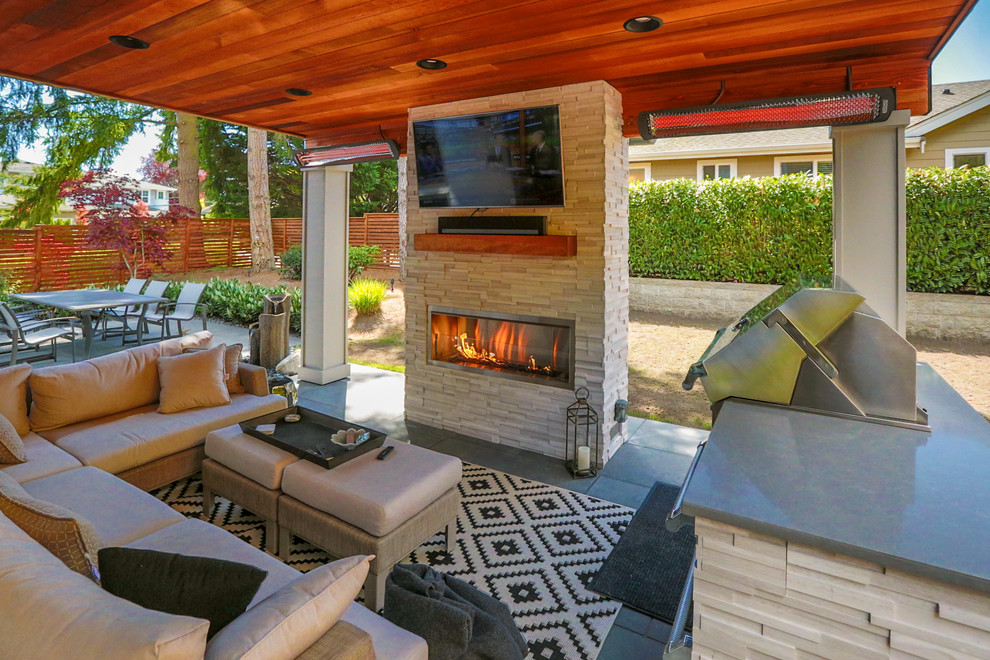 Exemple d'une terrasse arrière moderne de taille moyenne avec une cuisine d'été, des pavés en béton et une extension de toiture.