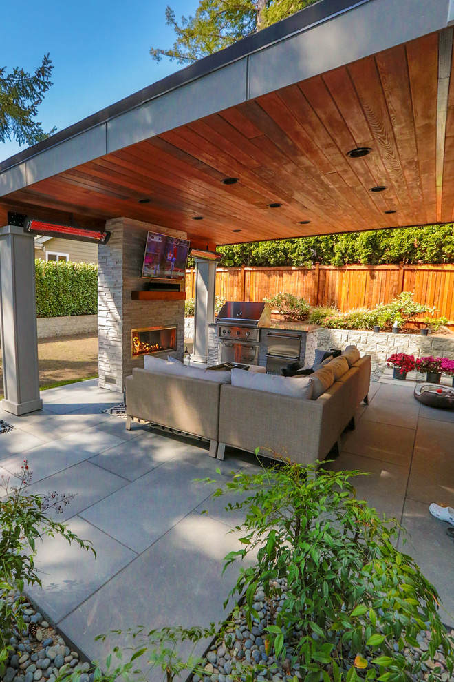 Ejemplo de patio moderno de tamaño medio en patio trasero y anexo de casas con cocina exterior y adoquines de hormigón