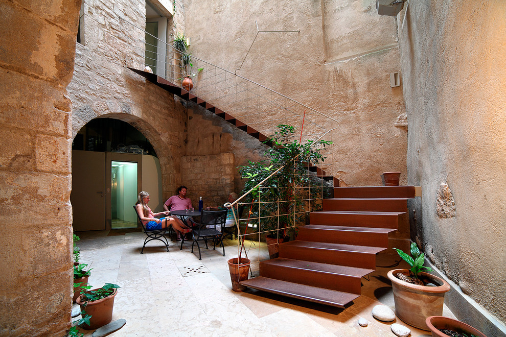 Пример оригинального дизайна: большой двор на внутреннем дворе в стиле фьюжн с растениями в контейнерах и покрытием из каменной брусчатки без защиты от солнца