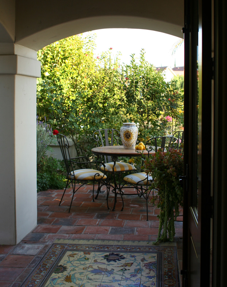 На фото: маленький двор на боковом дворе в средиземноморском стиле с мощением клинкерной брусчаткой без защиты от солнца для на участке и в саду с