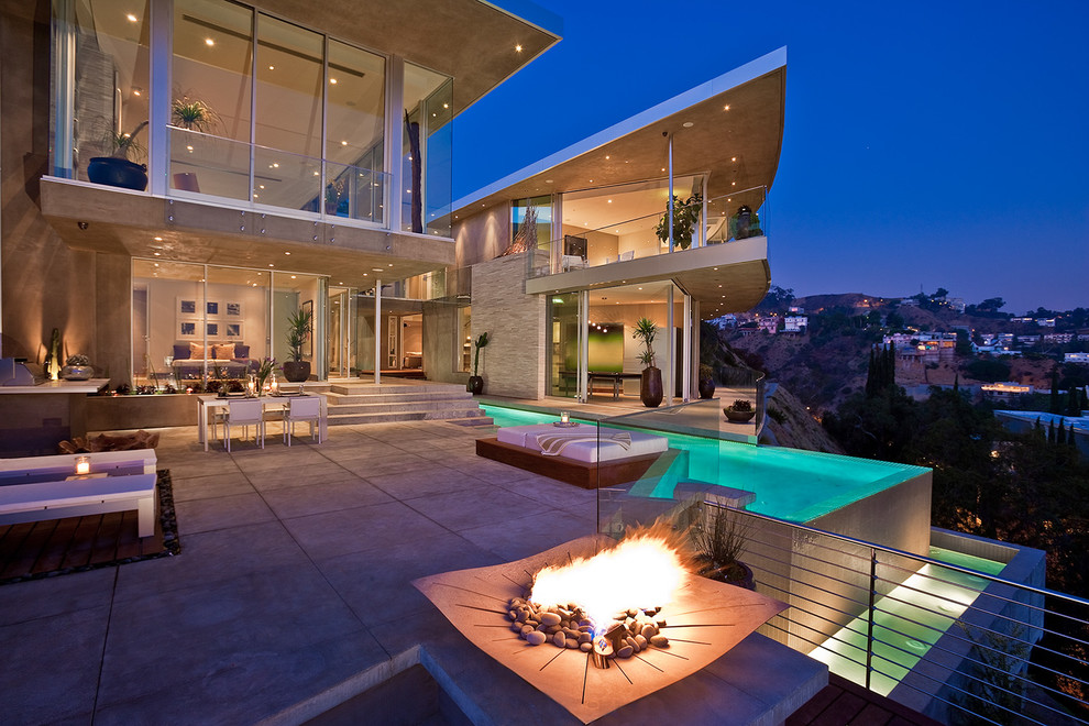 Example of a trendy concrete patio design in Los Angeles with a fire pit and no cover