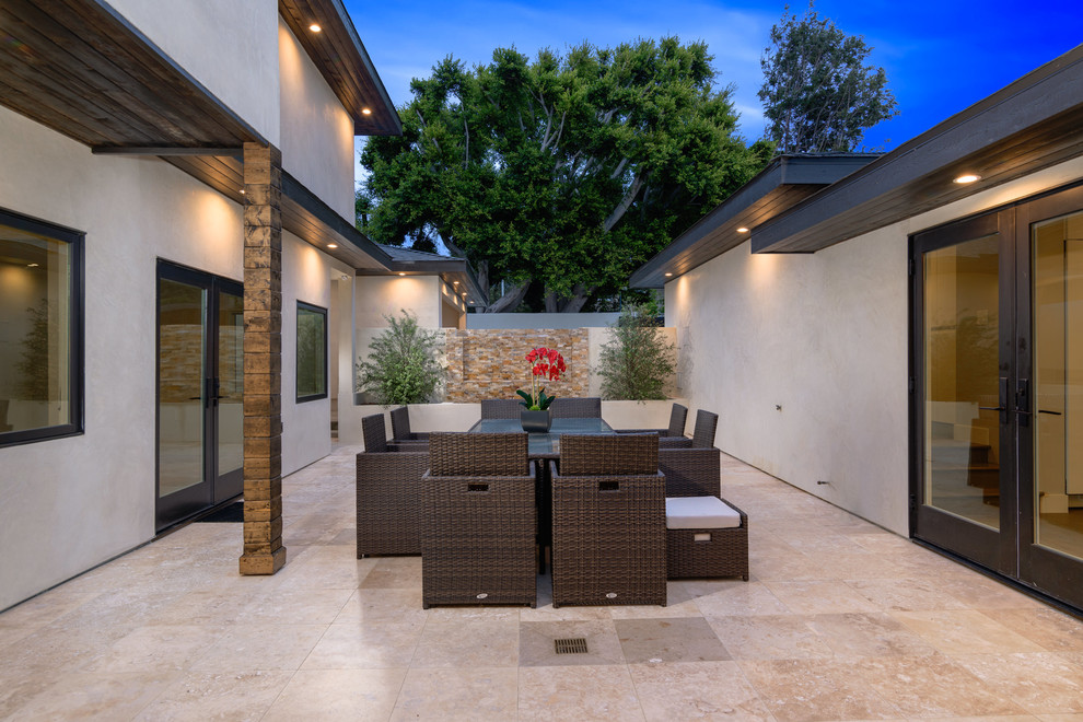 This is an example of a medium sized modern front patio in San Diego with a fire feature, decking and no cover.