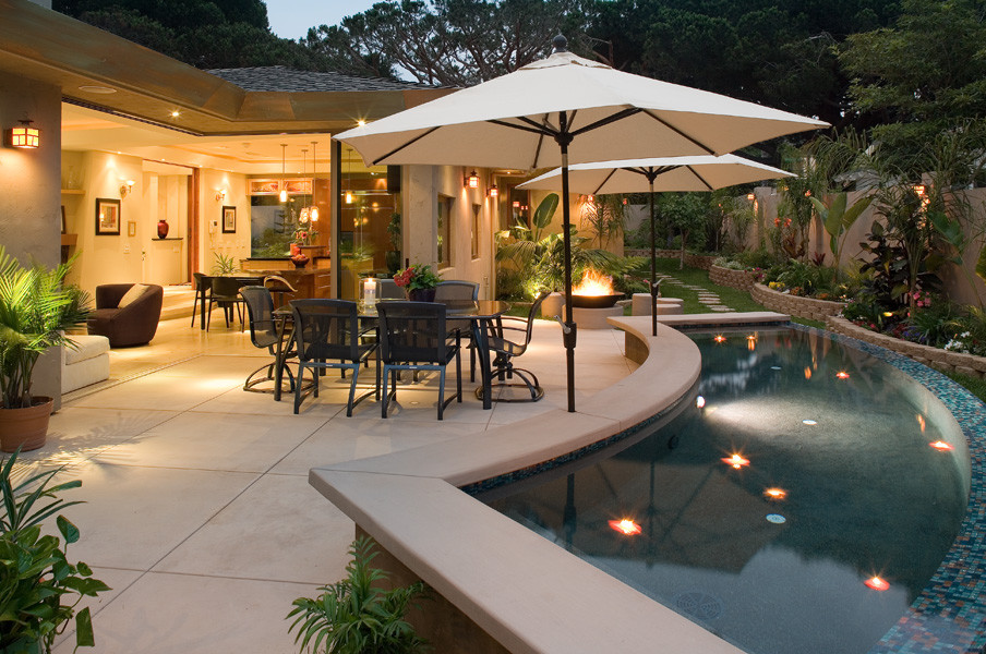 Ejemplo de patio minimalista de tamaño medio en patio con fuente, adoquines de hormigón y toldo