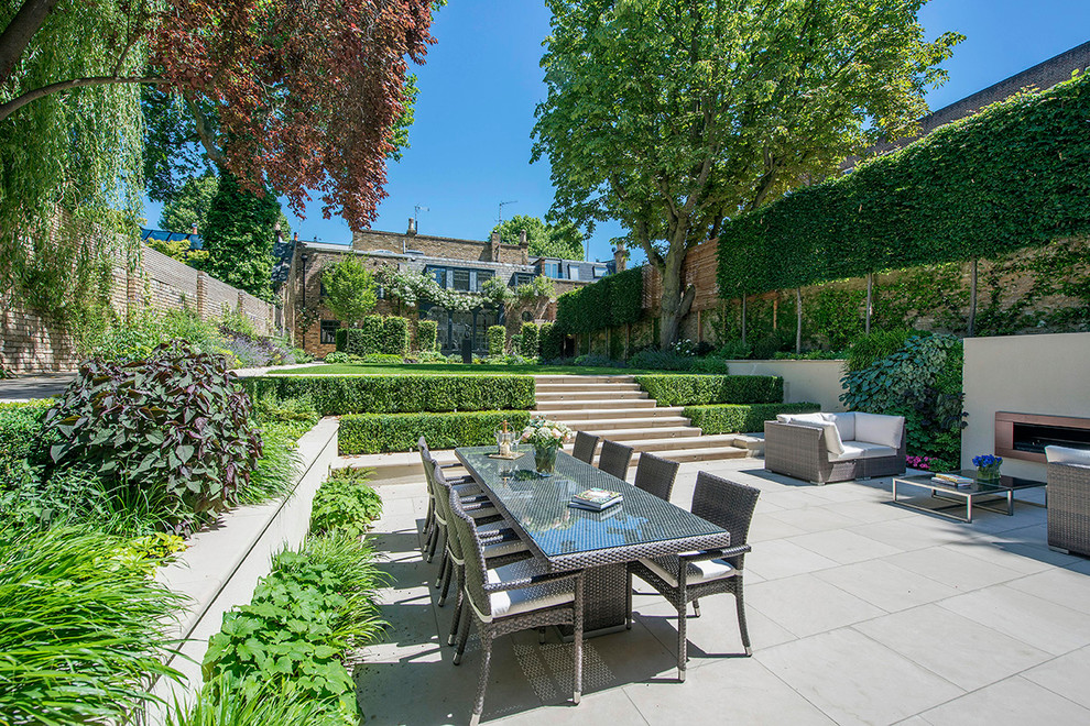 Mid-sized elegant backyard concrete paver patio photo in London