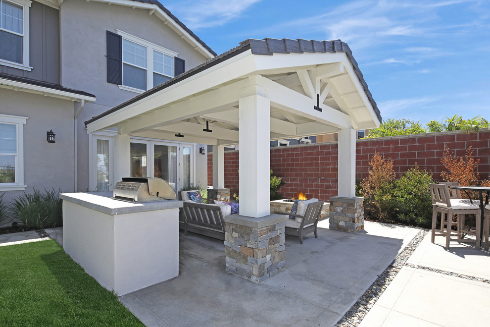 Esempio di un patio o portico design di medie dimensioni e dietro casa con fontane, lastre di cemento e un tetto a sbalzo