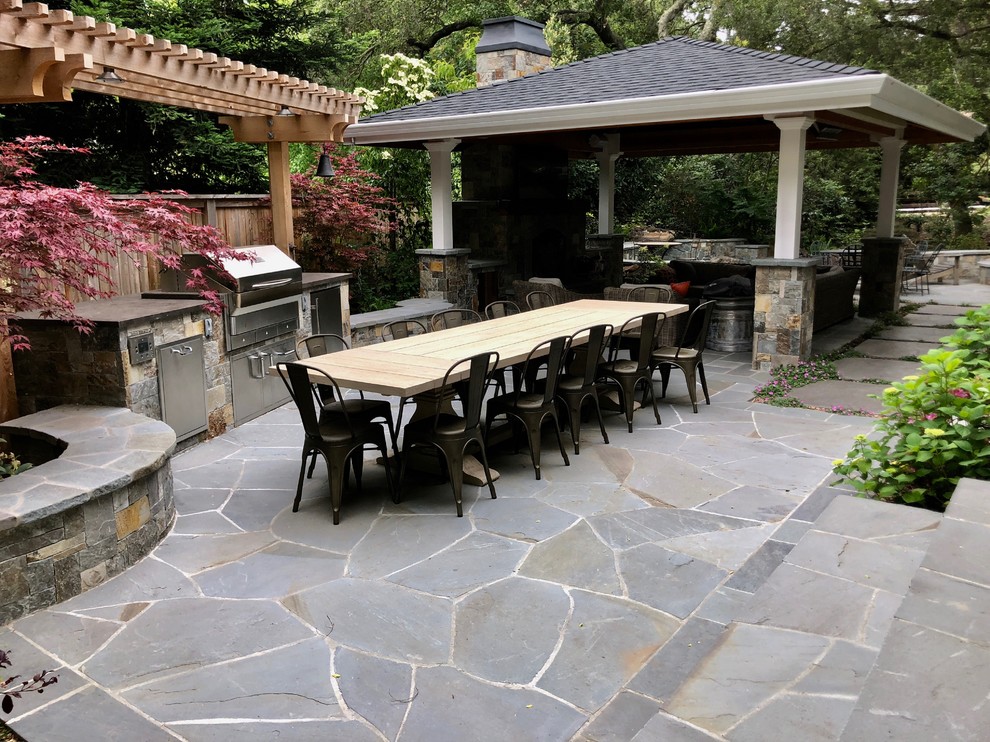 Cette image montre une terrasse arrière traditionnelle de taille moyenne avec des pavés en pierre naturelle et une cuisine d'été.