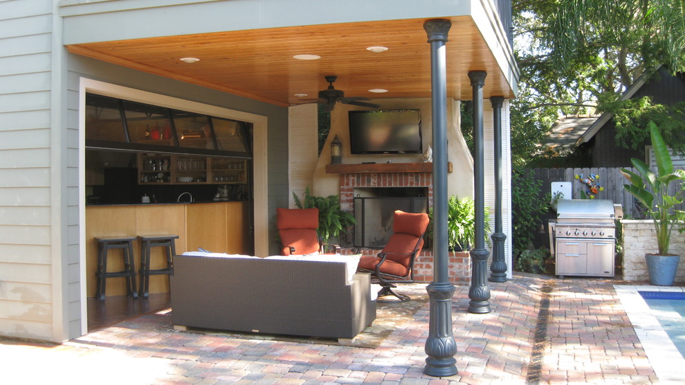 Photo of a small classic back patio in New Orleans with an outdoor kitchen, concrete paving and a roof extension.
