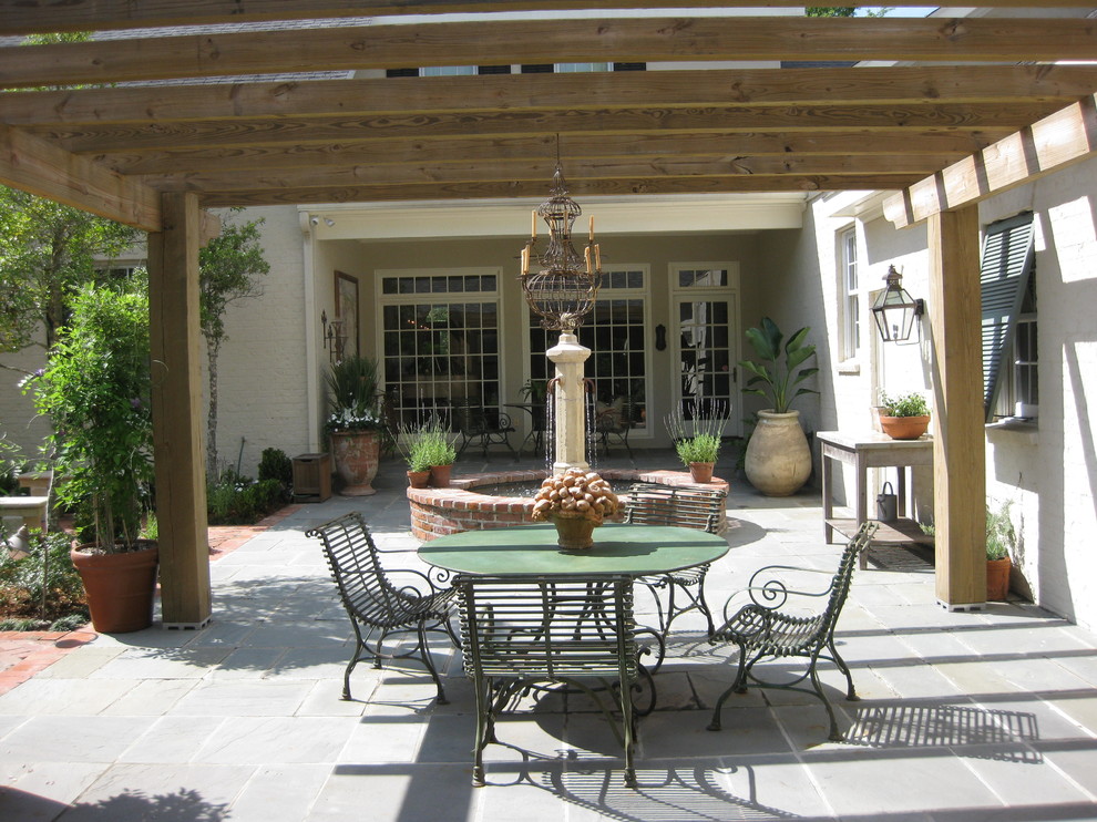 Ejemplo de patio clásico de tamaño medio en patio con adoquines de piedra natural y pérgola