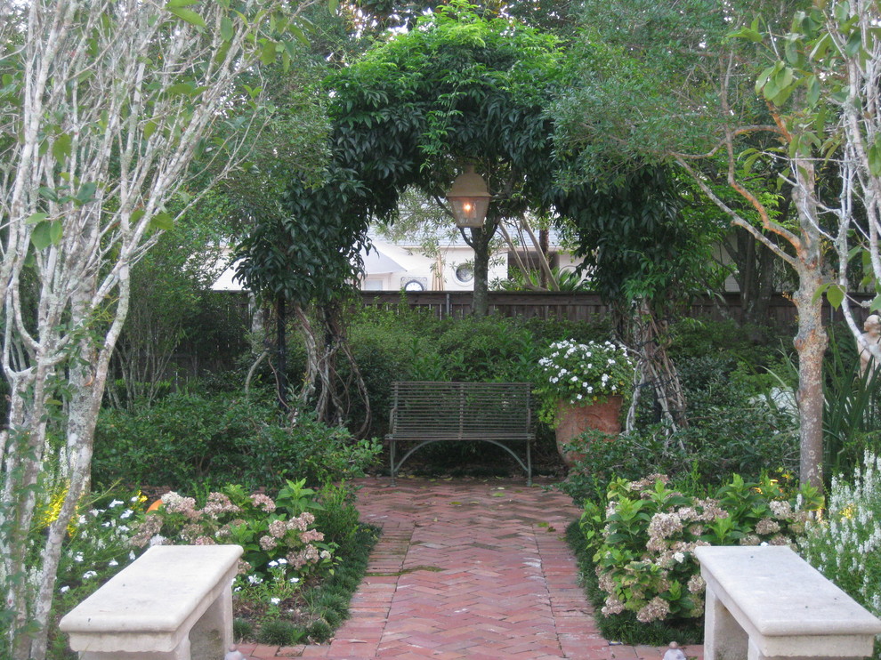 Diseño de patio tradicional de tamaño medio sin cubierta en patio lateral con fuente y adoquines de ladrillo