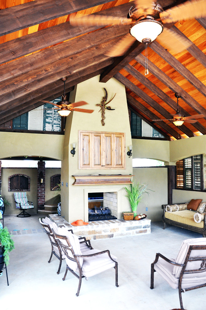Exemple d'une grande terrasse arrière chic avec une cuisine d'été, une dalle de béton et une extension de toiture.
