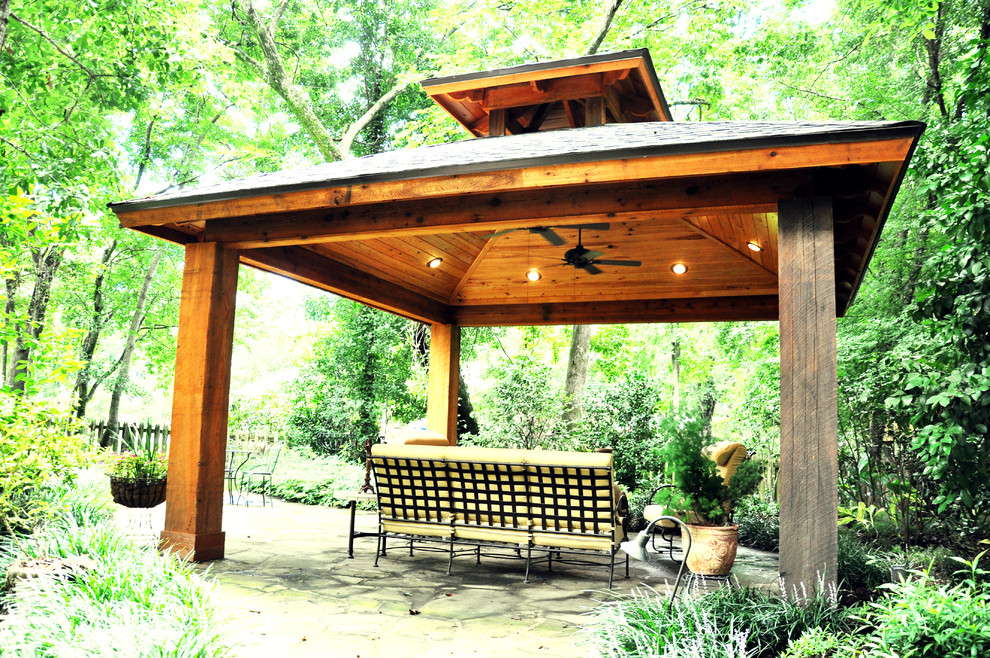 Inspiration pour une terrasse arrière traditionnelle de taille moyenne avec des pavés en pierre naturelle et une extension de toiture.